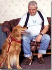 A man with a cane, with a dog at his side